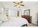 Bright bedroom with a ceiling fan, chest of drawers, and comfortable queen bed at 4532 Draper Rd, Raleigh, NC 27616