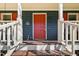 Close-up of front door with bright red paint, security camera, and welcoming decor at 4532 Draper Rd, Raleigh, NC 27616