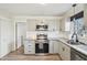 Updated kitchen features stainless steel appliances, granite counters, and white cabinetry at 4532 Draper Rd, Raleigh, NC 27616