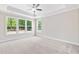 Light-filled bedroom featuring neutral walls, plush carpet, and large windows with wooded views at 4893 Grosbeak Ct, Mebane, NC 27302