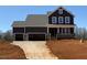 New two-story home featuring a three-car garage and a charming front porch with stone accents at 4893 Grosbeak Ct, Mebane, NC 27302