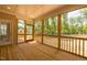 Covered porch with wood flooring and screens offering a relaxing outdoor space with views of the surrounding nature at 4893 Grosbeak Ct, Mebane, NC 27302