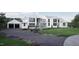 Elegant modern home with a three-car garage, manicured landscaping, and a long, paved driveway at 4900 Foxridge Dr, Raleigh, NC 27614