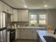 Bright kitchen features white cabinetry, stainless steel appliances, and quartz countertops at 512 Texas Ave, Burlington, NC 27217