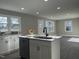 Bright kitchen with white cabinets, an island, stainless steel appliances, and gray flooring at 512 Texas Ave, Burlington, NC 27217