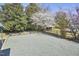 A gravel-covered backyard, accented with flowering trees and blue potted plants, offering serene outdoor space at 523 N Main St, Graham, NC 27253