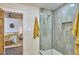 Bathroom featuring a glass shower and a bedroom with wood-paneled ceiling in the background at 523 N Main St, Graham, NC 27253