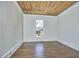 Bright bedroom featuring hardwood floors, white walls, wood ceiling, and natural light from the window at 523 N Main St, Graham, NC 27253