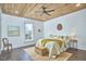 Bright bedroom featuring a wood-paneled ceiling, white walls, and hardwood floors with neutral decor and ample light at 523 N Main St, Graham, NC 27253