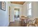 Dining area with a wood ceiling, quaint table, and rattan chairs, creating a warm and inviting space at 523 N Main St, Graham, NC 27253