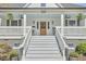 Inviting front porch with comfortable seating, ceiling fans, and a charming wooden door with glass at 523 N Main St, Graham, NC 27253