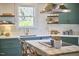 Eat-in kitchen with a large window, white countertops, and stylish green cabinetry at 523 N Main St, Graham, NC 27253