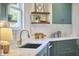 Bright eat-in kitchen with a gold faucet, white countertops, and green cabinets at 523 N Main St, Graham, NC 27253
