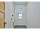 Laundry room with a utility sink hookup, a window, and a modern, gray tile floor at 523 N Main St, Graham, NC 27253