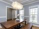 Bright dining room with a wooden table, stylish chandelier, and large windows at 543 Chatham Forest Dr, Pittsboro, NC 27312