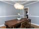 Dining room with wood table, unique light fixture, and view into kitchen area at 543 Chatham Forest Dr, Pittsboro, NC 27312