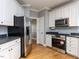 Well-lit kitchen featuring stainless steel appliances, light cabinets, and hardwood floors at 543 Chatham Forest Dr, Pittsboro, NC 27312