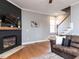 Cozy living room featuring hardwood floors, a black fireplace, and stairs leading to the second floor at 543 Chatham Forest Dr, Pittsboro, NC 27312