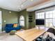 Comfortable office space featuring a large desk, an inviting blue couch, and ample natural light at 543 Chatham Forest Dr, Pittsboro, NC 27312