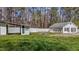 Well-maintained property showcasing an outdoor building and garage surrounded by lush greenery at 5437 Grasshopper Rd, Raleigh, NC 27610