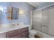 Cozy bathroom featuring a vanity, toilet, and shower-tub with glass sliding doors at 5437 Grasshopper Rd, Raleigh, NC 27610