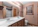Bathroom with double sinks, wood cabinets, tile floor, toilet, shower and large mirror at 5437 Grasshopper Rd, Raleigh, NC 27610