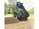Truck unloading mulch for landscaping on a sunny day at 5437 Grasshopper Rd, Raleigh, NC 27610