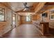 Spacious living area featuring hardwood floors, a ceiling fan, and wooden walls and cabinetry at 5437 Grasshopper Rd, Raleigh, NC 27610