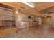 A rustic living area features wood paneling, a ceiling fan, and built in shelving at 5437 Grasshopper Rd, Raleigh, NC 27610
