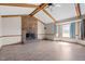Living room with vaulted ceiling, wooden beams, brick fireplace, tile floor, and bay window at 5437 Grasshopper Rd, Raleigh, NC 27610