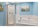 Bathroom boasts separate glass shower, soaking tub and blue walls at 5569 Sea Daisy Dr, Raleigh, NC 27606