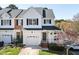 Charming two-story townhome featuring attached garage, black shutters, covered porch, and well-maintained lawn at 5569 Sea Daisy Dr, Raleigh, NC 27606