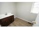 Bathroom featuring a wood vanity, a sink, modern fixtures, wood floors and a window for natural light at 608 Cecil St, Durham, NC 27707