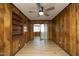 Living room with wood paneled walls, ceiling fan and access to enclosed porch at 608 Cecil St, Durham, NC 27707