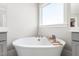 Elegant soaking tub with a window view, perfect for relaxation in a modern bathroom at 6108 Norwood Place Ct, Raleigh, NC 27613