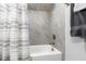 Bathroom showcasing a shower-bathtub combination with gray tiling and a patterned shower curtain at 6108 Norwood Place Ct, Raleigh, NC 27613