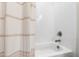 Clean bathroom with a white tiled wall and bathtub, complemented by a neutral-striped shower curtain at 6108 Norwood Place Ct, Raleigh, NC 27613