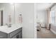Stylish bathroom with a gray vanity, and a bedroom view with white bed and neutral pink decor at 6108 Norwood Place Ct, Raleigh, NC 27613