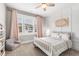 Charming bedroom showcasing a white spindle bed, soft pink curtains, and a cozy reading nook by the window at 6108 Norwood Place Ct, Raleigh, NC 27613