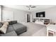 Spacious bedroom featuring a gray sectional, ceiling fan, and built-in shelving beneath a wall-mounted TV at 6108 Norwood Place Ct, Raleigh, NC 27613