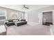 Bright bedroom showcasing a comfortable gray sectional sofa beneath two windows with a rainbow-themed artwork at 6108 Norwood Place Ct, Raleigh, NC 27613