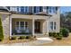 Inviting front porch with stone accents, white columns, and comfortable seating, perfect for enjoying the outdoors at 6108 Norwood Place Ct, Raleigh, NC 27613