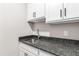 Laundry room features a stainless sink and granite countertops with sleek, modern cabinets at 6108 Norwood Place Ct, Raleigh, NC 27613