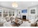 Bright living room features a fireplace, TV, large windows, hardwood floors, and comfortable seating at 6108 Norwood Place Ct, Raleigh, NC 27613