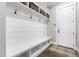 Mudroom with built-in storage, bench, hooks, and access to front door, offering organized entry at 6108 Norwood Place Ct, Raleigh, NC 27613