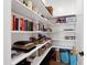 Pantry shelving filled with books, boxes, bags, and other items for plentiful storage at 6108 Norwood Place Ct, Raleigh, NC 27613