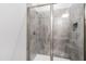 Modern shower featuring gray tile, glass doors, and niche storage at 6108 Norwood Place Ct, Raleigh, NC 27613