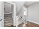 Bright stairway with carpeted stairs and a safety gate, connecting different levels of the home at 6108 Norwood Place Ct, Raleigh, NC 27613