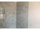 Corner of tiled bathroom with shelving niche and modern gray tiling at 65 Stream View Way, Spring Hope, NC 27882