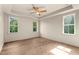 Bright bedroom with hardwood floors, tray ceiling, ceiling fan and large windows at 65 Stream View Way, Spring Hope, NC 27882